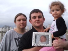 Buncrana couple Toni Stemp and Chris McFadden pictured in the garden of their Carrick Fern home with daughter Alix and a photo of their beloved Shae.