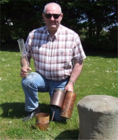 John McClenaghan shows the rainfall gauge he uses at his home.