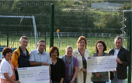 Marthon relay team members present their fundraising cheques to Sinead McLaughlin, Principal Scoil Iosagain.