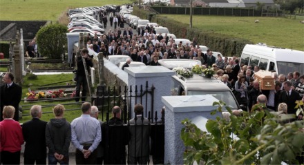 The cortege makes its way to the church gates.